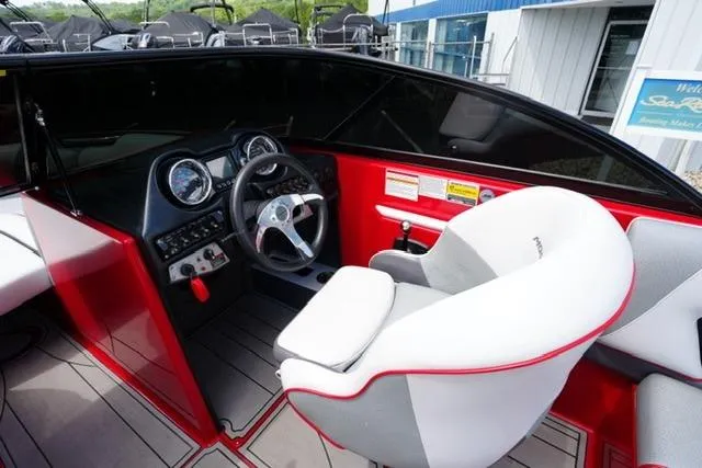 Slide: The Image of 2015 Moomba Mojo boat interior with steering wheel and captain's chair. - 13