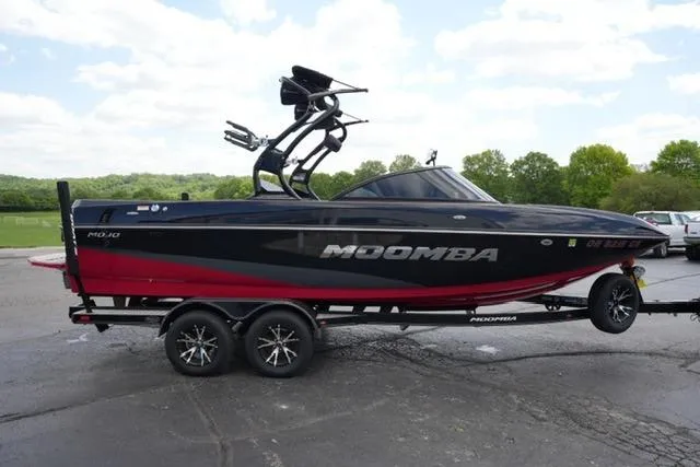 Slide: The Image of 2015 Moomba Mojo boat on trailer, black and red design, parked outdoors. - 4