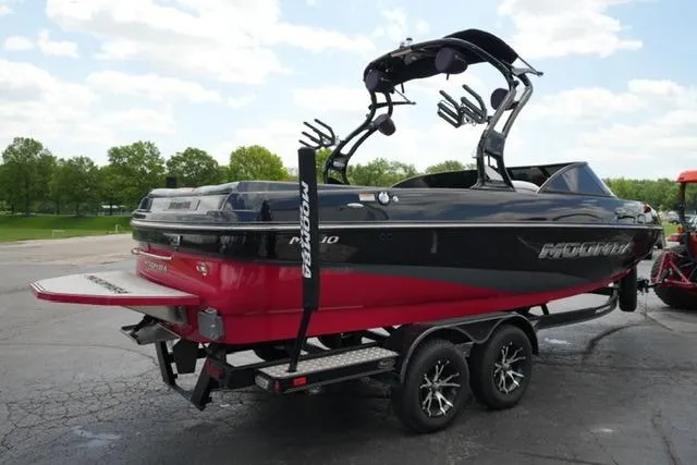 Slide: The Image of 2015 Moomba Mojo boat on trailer, red and black design, parked outdoors. - 5