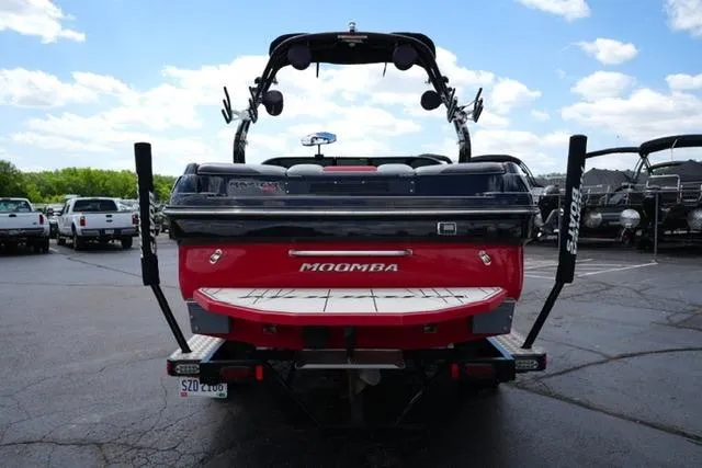 Slide: The Image of 2015 Moomba Mojo boat, rear view, parked in a lot under a partly cloudy sky. - 6