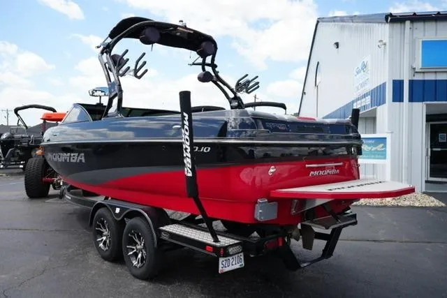 Slide: The Image of 2015 Moomba Mojo boat on trailer, red and black design, parked outside a building. - 7
