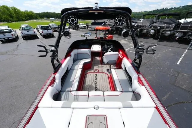 Slide: The Image of 2015 Moomba Mojo boat interior with red and white seating, parked in a lot. - 8
