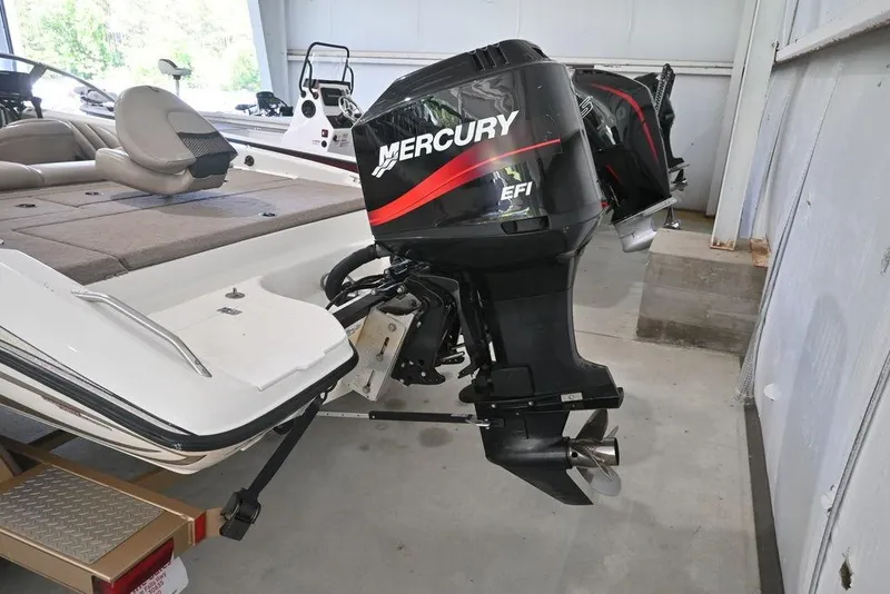 Slide: The Image of 2004 Stratos 290 Ski-N-Fish boat with Mercury EFI outboard motor in a garage. - 2