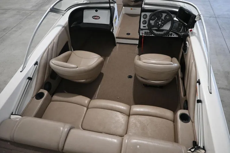 Slide: The Image of 2004 Stratos 290 Ski-N-Fish boat interior with beige seating and steering console. - 6