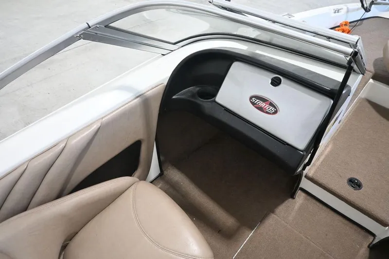 Slide: The Image of 2004 Stratos 290 Ski-N-Fish boat interior with beige seating and storage compartment. - 8
