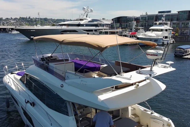 Slide: The Image of 2017 Prestige 500 yacht docked in a marina, featuring a spacious upper deck and modern design. - 9