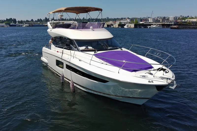 Slide: The Image of 2017 Prestige 500 yacht cruising on a sunny day, featuring a sleek design and purple deck cover. - 5