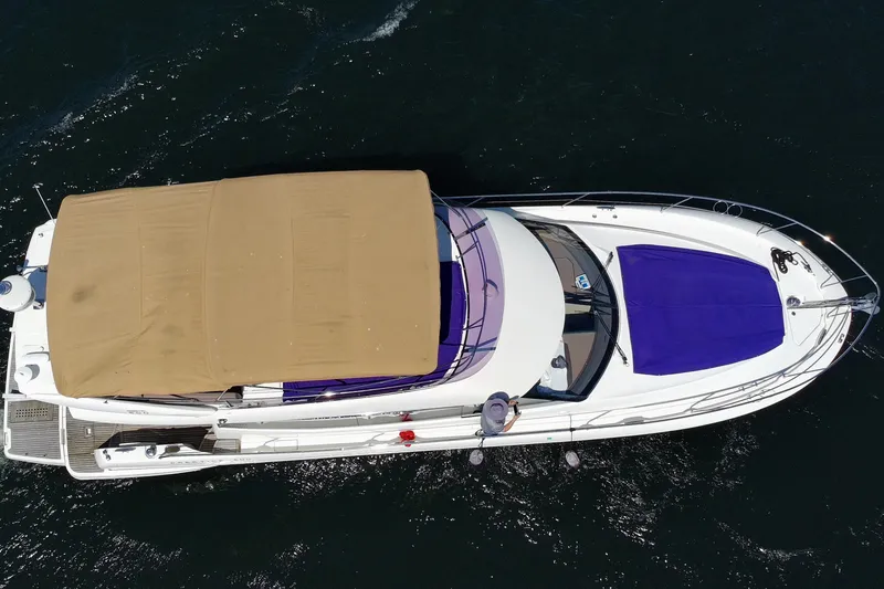 Slide: The Image of Aerial view of 2017 Prestige 500 yacht with beige canopy and blue covers on water. - 7