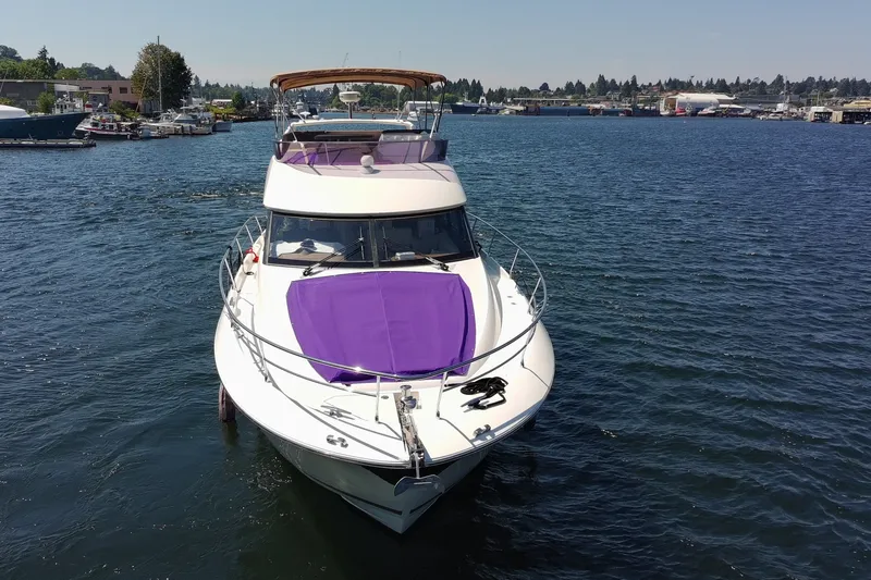 Slide: The Image of Luxurious 2017 Prestige 500 yacht on serene water, featuring a vibrant purple sunpad. - 6