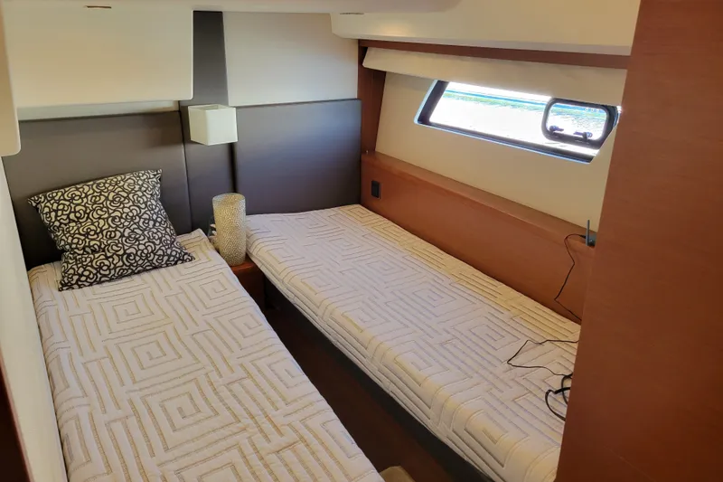 Slide: The Image of Twin cabin interior of 2017 Prestige 500 yacht with modern decor and window view. - 34