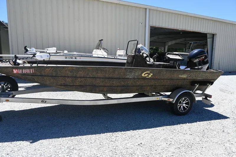 The Image of 2025 G3 Gator Tough 20 CC boat on trailer, parked outside a metal building. - 1