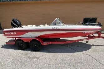 Slide: The Image of 2006 Nitro 288 Sport boat on trailer, red and white design, parked outdoors. - 1
