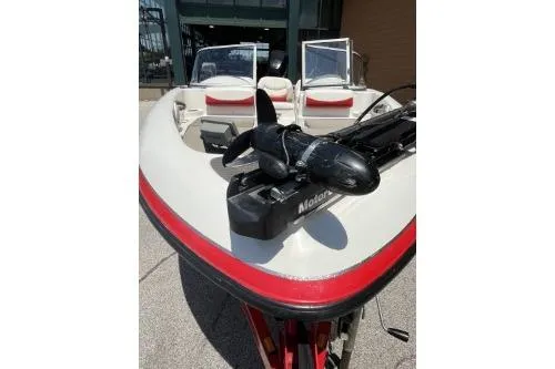 Slide: The Image of 2006 Nitro 288 Sport boat with trolling motor, red and white interior, docked outdoors. - 4