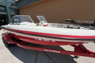 Slide: The Image of 2006 Nitro 288 Sport boat with red trailer parked outdoors. - 7
