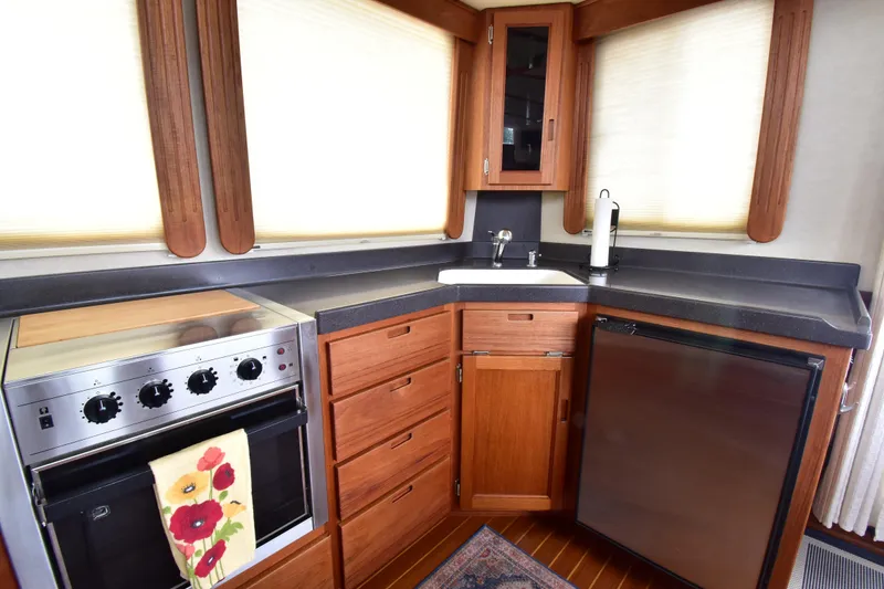 Slide: The Image of Galley kitchen in 2007 Nordic Tug 37 with stove, sink, and refrigerator. - 13