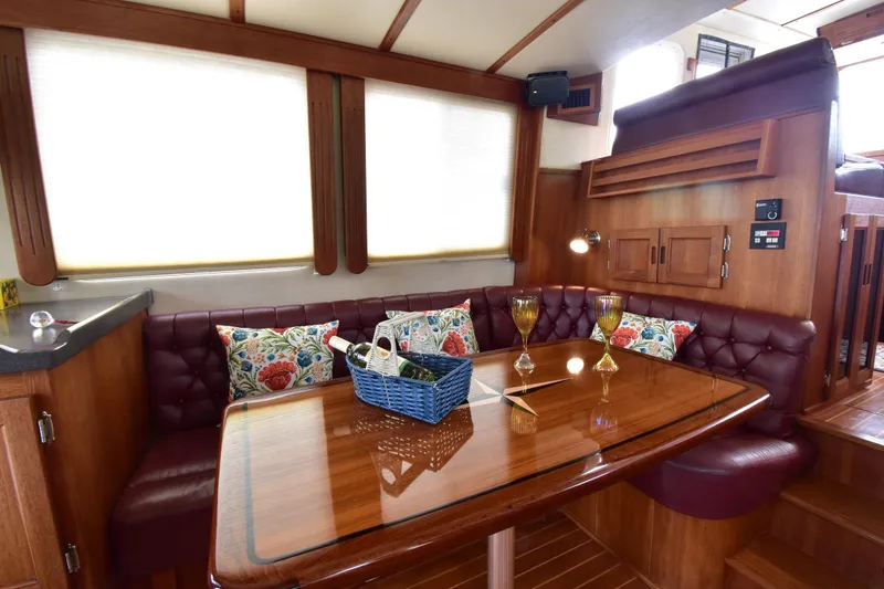 Slide: The Image of Luxurious 2007 Nordic Tug 37 interior with plush seating, wooden table, and decorative pillows. - 15