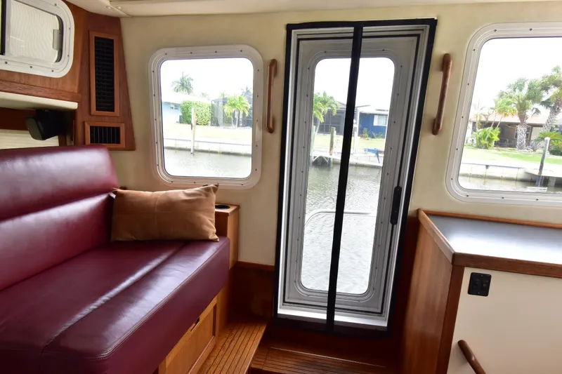Slide: The Image of Interior of a 2007 Nordic Tug 37, featuring a cozy seating area and waterfront view. - 17