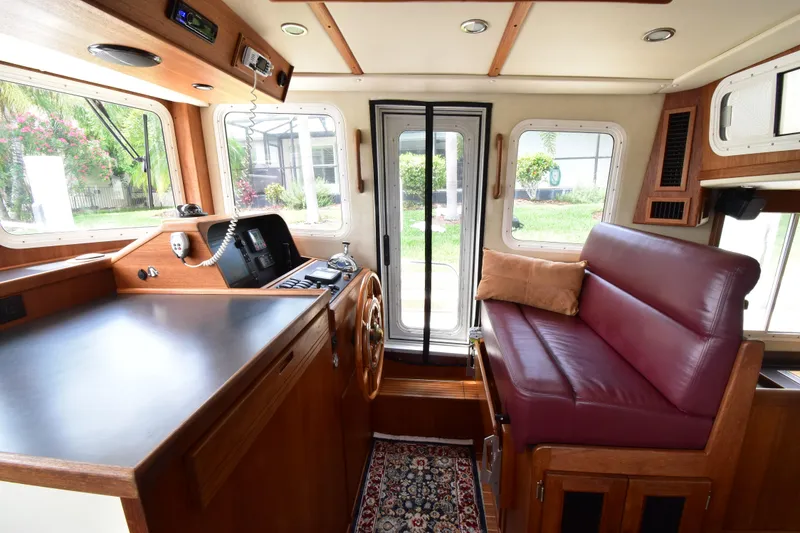 Slide: The Image of Interior of 2007 Nordic Tug 37 with helm, seating, and large windows. - 18