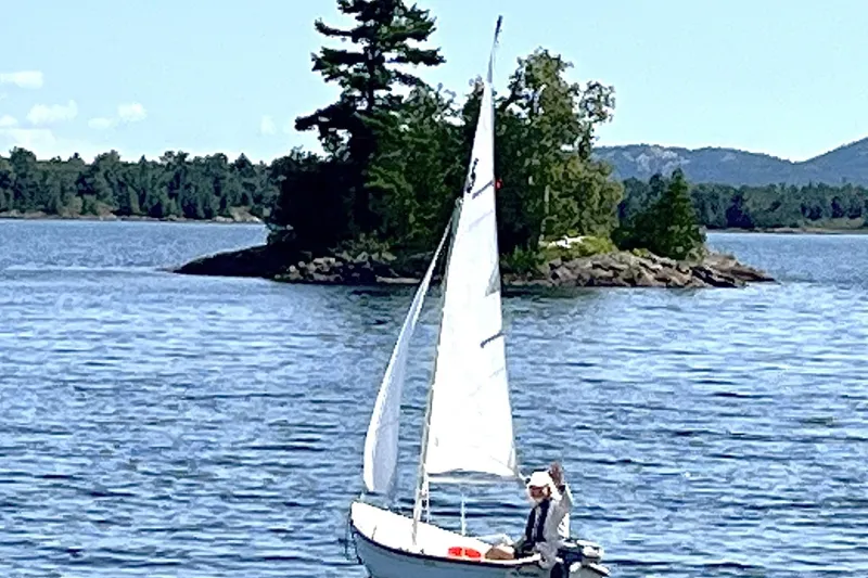 Slide: The Image of Sailboat on a serene lake with lush island backdrop, Nordic Tug 37, 2007 model. - 26
