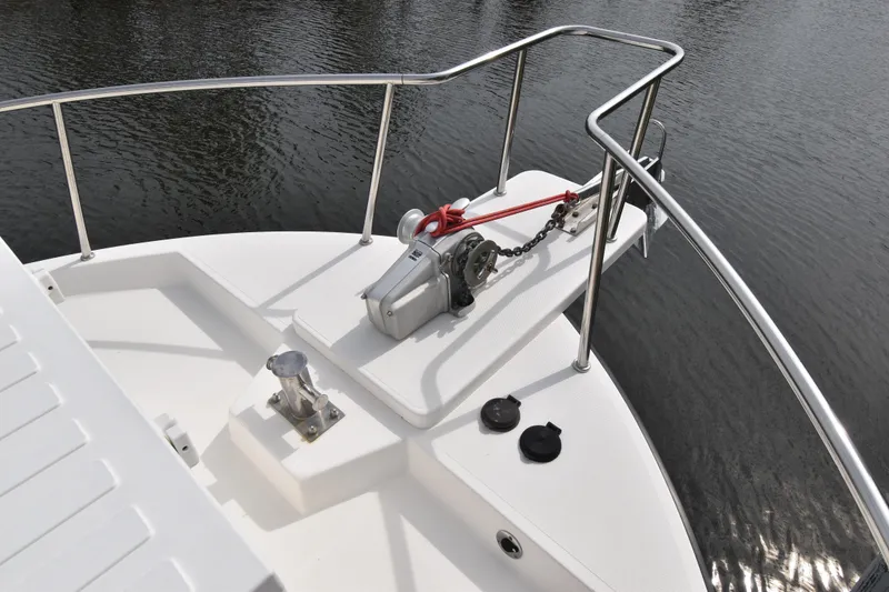 Slide: The Image of Bow of 2007 Nordic Tug 37 with anchor winch and railing on calm water. - 4