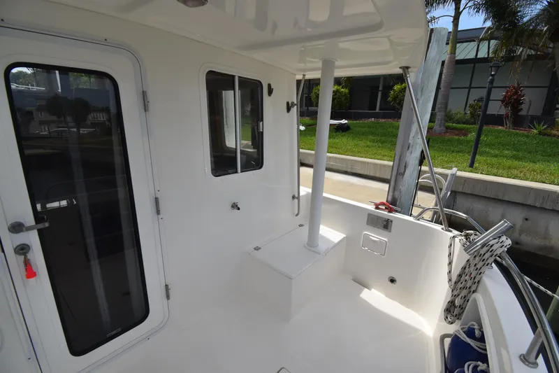 Slide: The Image of 2007 Nordic Tug 37 boat deck with door, windows, and dockside view. - 6