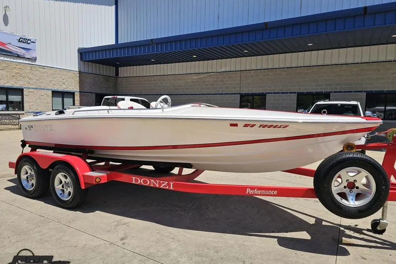 Slide: The Image of 1997 Donzi 18 Classic boat on red trailer, parked outside a building. - 14