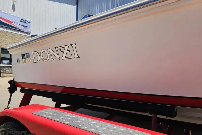 Slide: The Image of 1997 Donzi 18 Classic boat on red trailer, showcasing sleek design and branding. - 16