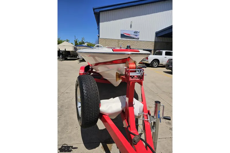 Slide: The Image of 1997 Donzi 18 Classic boat on red trailer, parked outside a building. - 23