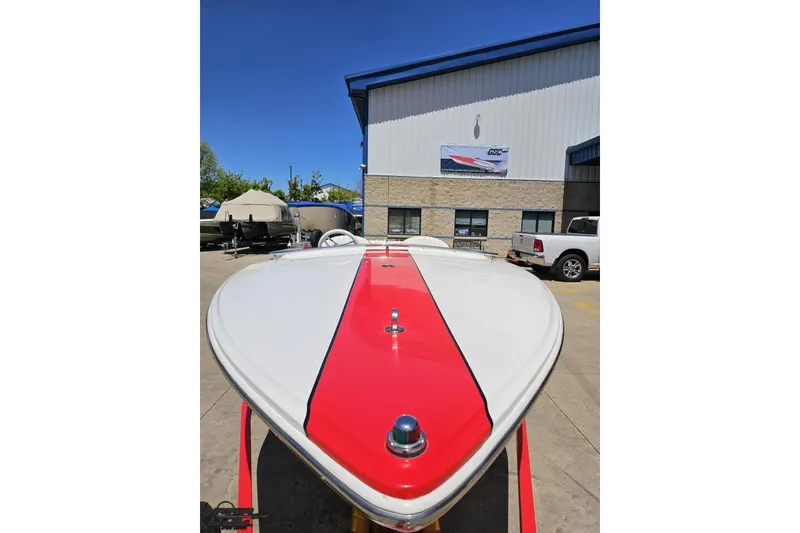 Slide: The Image of 1997 Donzi 18 Classic boat with red stripe, parked outdoors near a building. - 25
