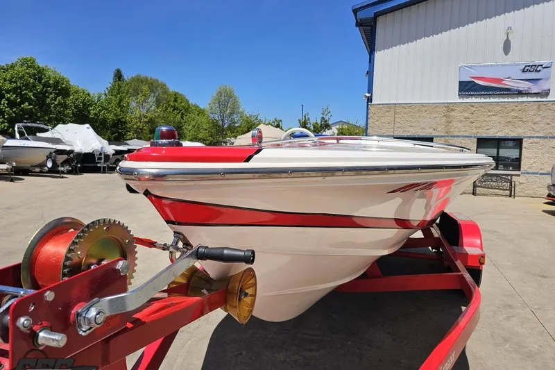 Slide: The Image of 1997 Donzi 18 Classic boat on red trailer, parked outdoors under clear blue sky. - 26