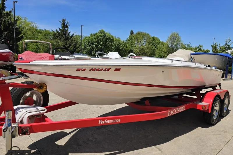 Slide: The Image of 1997 Donzi 18 Classic boat on red trailer, parked outdoors on a sunny day. - 28