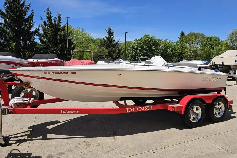 Slide: The Image of 1997 Donzi 18 Classic boat on red trailer, parked outdoors on a sunny day. - 29