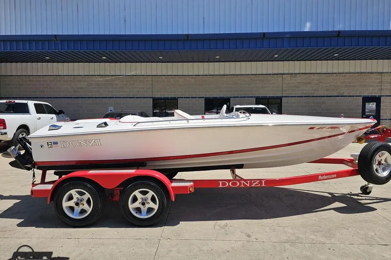 Slide: The Image of 1997 Donzi 18 Classic boat on red trailer, parked outside a building. - 3