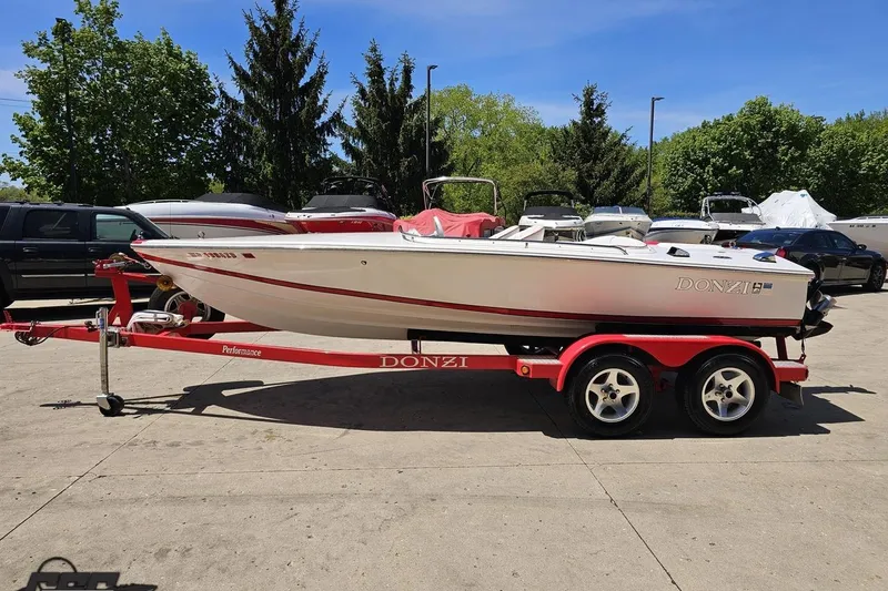 Slide: The Image of 1997 Donzi 18 Classic boat on a red trailer, parked outdoors. - 30