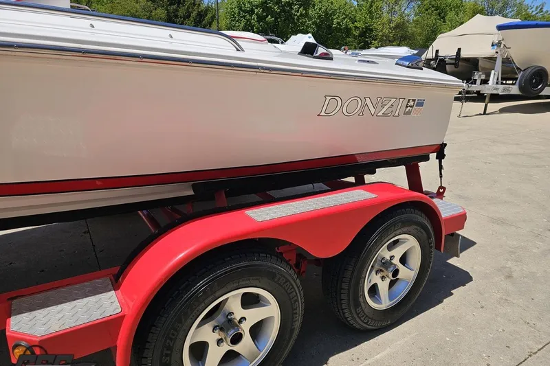 Slide: The Image of 1997 Donzi 18 Classic boat on red trailer, parked outdoors. - 32