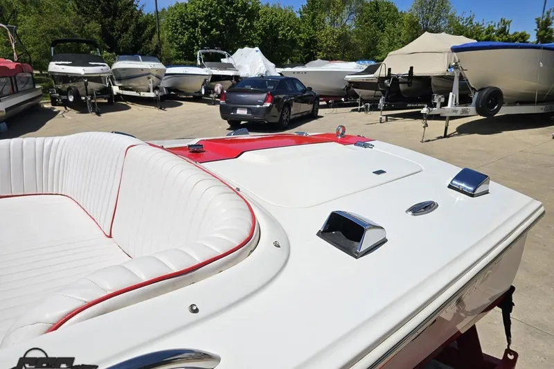 Slide: The Image of 1997 Donzi 18 Classic boat with white and red interior, parked among other boats. - 33
