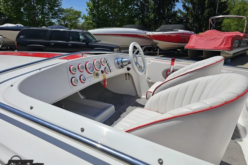 Slide: The Image of 1997 Donzi 18 Classic boat interior with white seats and red accents, parked outdoors. - 35