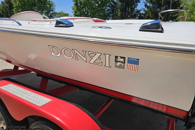 Slide: The Image of 1997 Donzi 18 Classic boat on red trailer, showcasing sleek design and branding. - 37