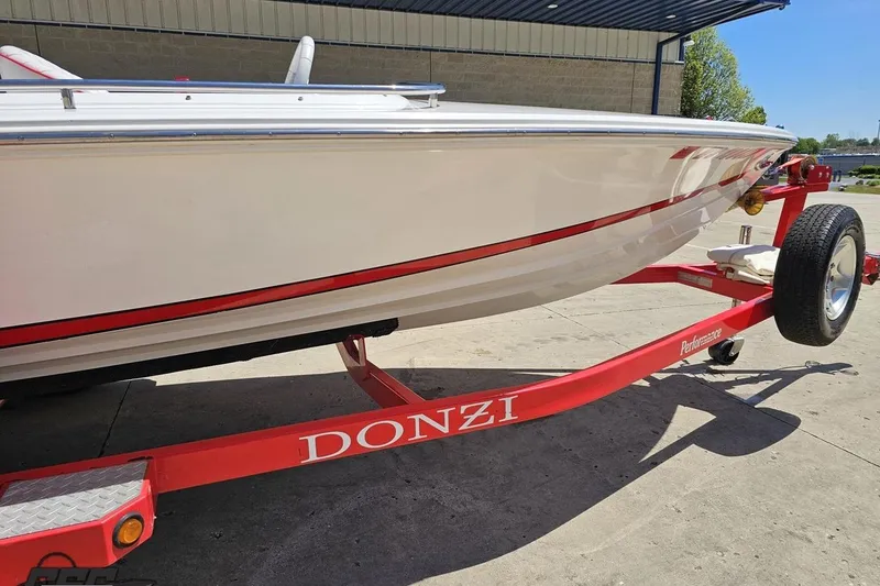 Slide: The Image of 1997 Donzi 18 Classic boat on a red trailer, parked outdoors. - 4