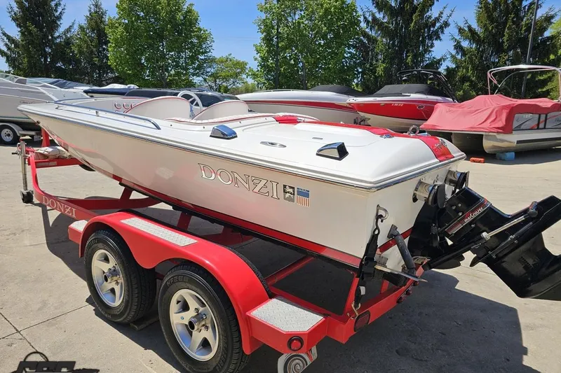 Slide: The Image of 1997 Donzi 18 Classic boat on a red trailer, parked outdoors. - 42