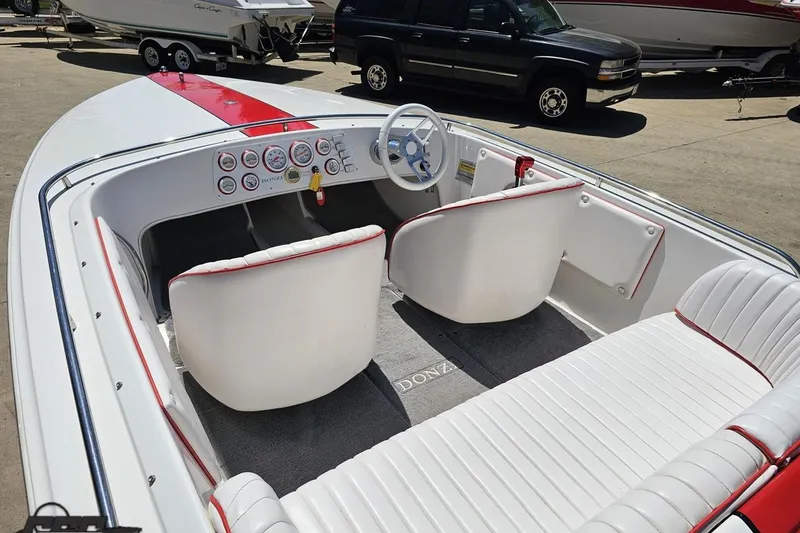 Slide: The Image of 1997 Donzi 18 Classic boat interior with white and red seating, dashboard, and steering wheel. - 63