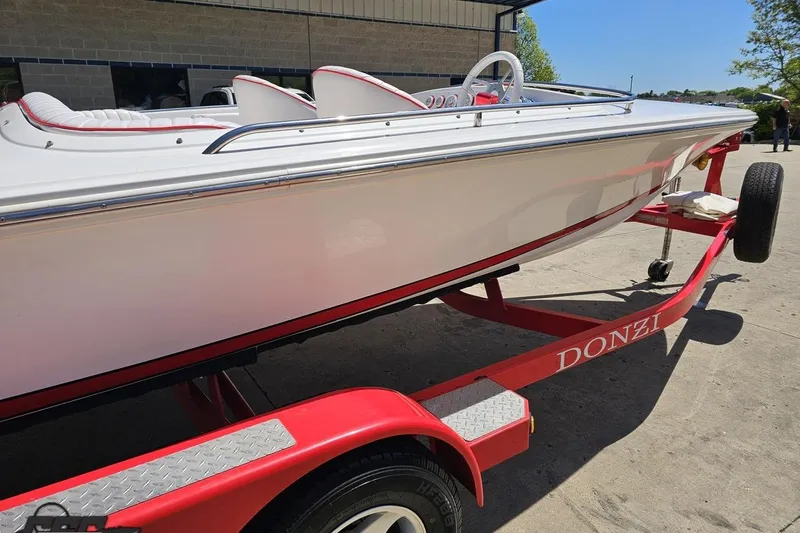 Slide: The Image of 1997 Donzi 18 Classic boat on a red trailer, parked outdoors. - 7