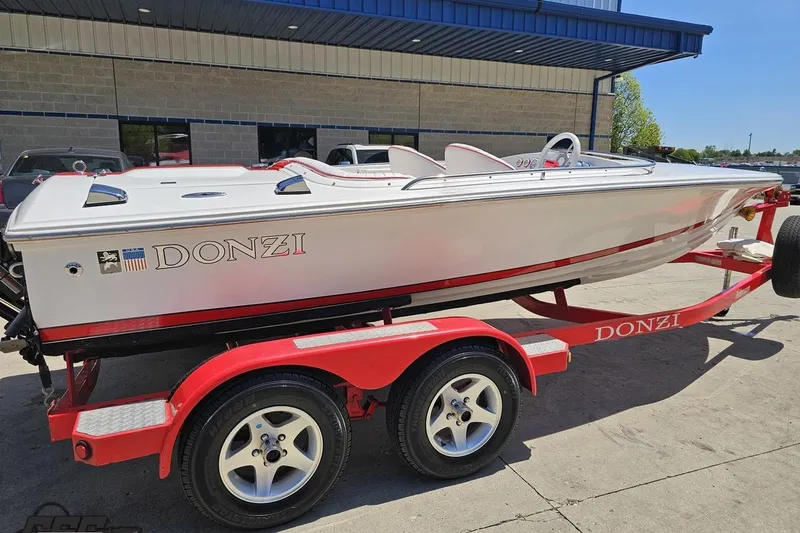 Slide: The Image of 1997 Donzi 18 Classic boat on red trailer, parked outside a building. - 8