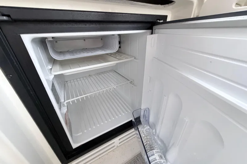 Slide: The Image of Open refrigerator inside 2001 Sea Ray 380 Sundancer yacht, showing empty shelves and a water bottle. - 11
