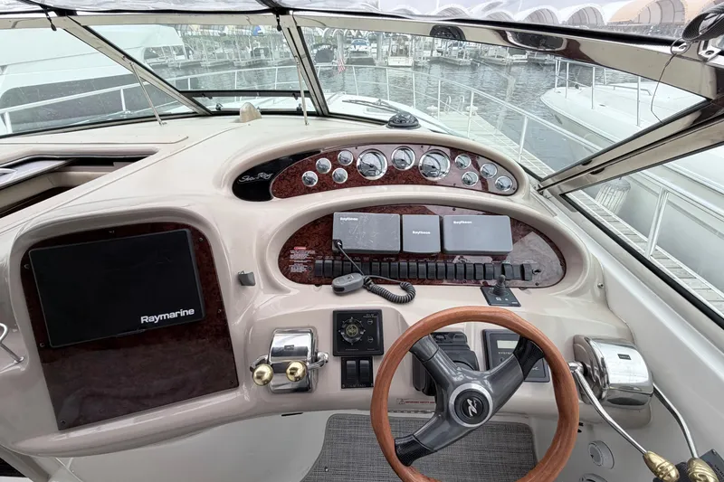 Slide: The Image of 2001 Sea Ray 380 Sundancer helm with Raymarine electronics and wood-accented steering wheel. - 14