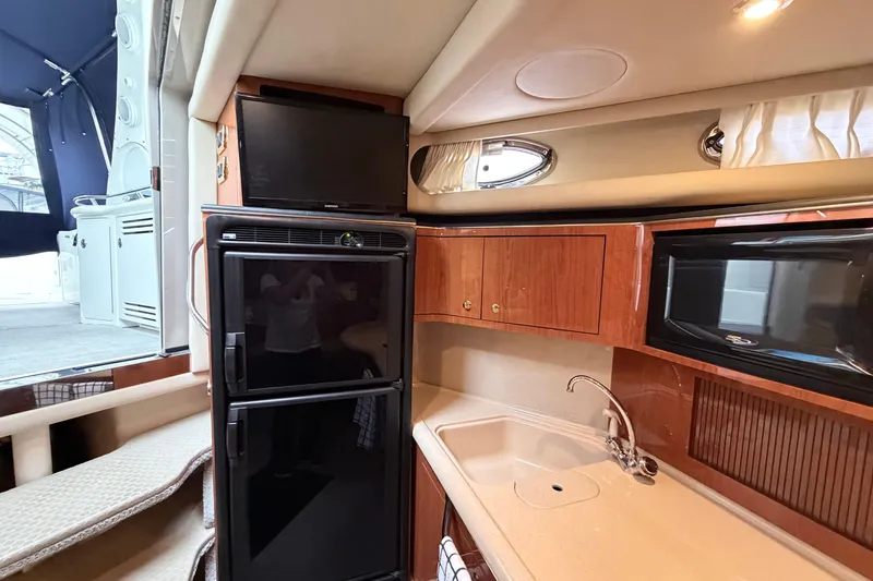 Slide: The Image of Interior of 2001 Sea Ray 380 Sundancer yacht with kitchenette, TV, and appliances. - 23