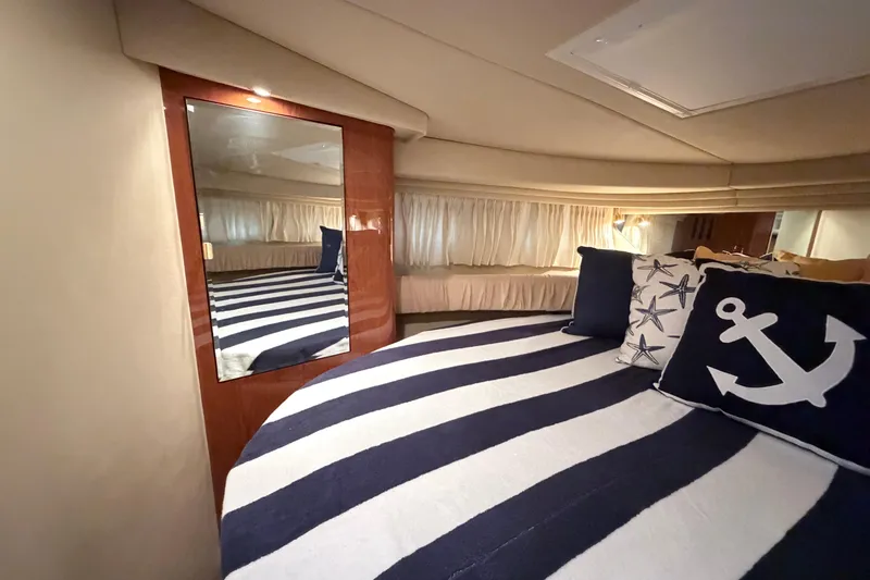 Slide: The Image of Interior of 2001 Sea Ray 380 Sundancer with nautical-themed bedding and mirror. - 29