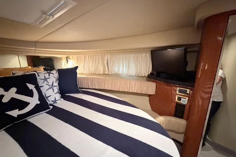 Slide: The Image of Interior of 2001 Sea Ray 380 Sundancer with striped bedding and nautical-themed pillows. - 30