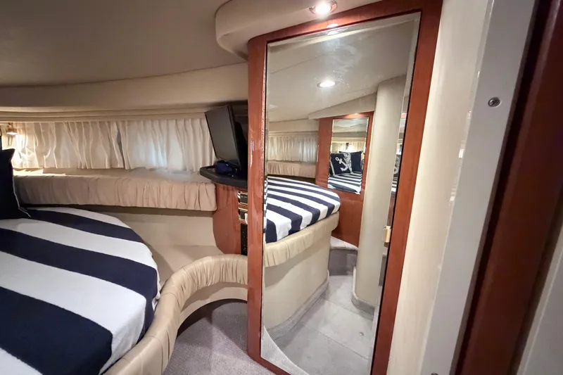 Slide: The Image of Interior of 2001 Sea Ray 380 Sundancer with striped bedding and mirrored closet. - 31