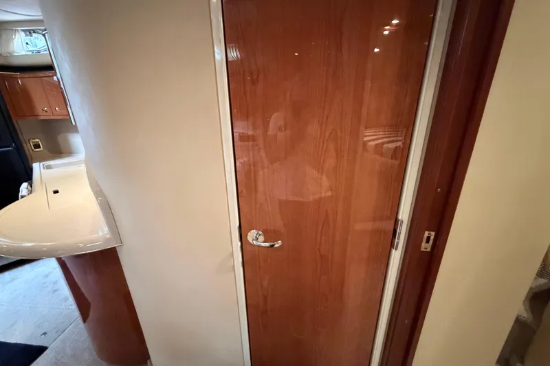 Slide: The Image of Interior of 2001 Sea Ray 380 Sundancer, featuring a wooden door and compact sink. - 32
